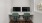  Two computer monitors are sitting on a desk with green chairs.