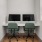  Two computer monitors are sitting on a desk with green chairs.