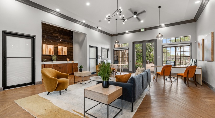  A modern room with a sofa, chairs, and a table with a green plant.
