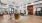  A modern room with a large rug in the center and seating around it.