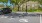  A black car is parked in a parking spot with a building in the background.
