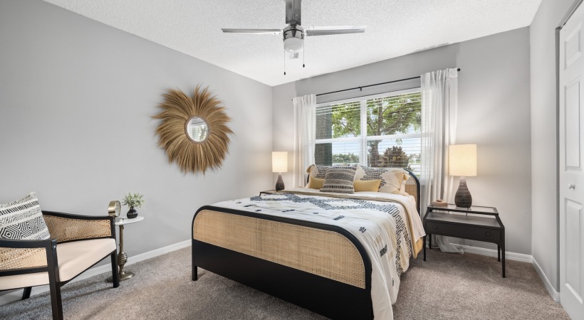  A bedroom with a bed, a bench, and a wall decoration.