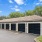  A building with a brown roof and black garage doors.