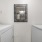  A white washer & dryer and a mirror on the wall.