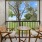  A patio with a table and two chairs overlooking a green lawn.