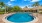  A round swimming pool surrounded by a brick border.