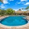  A round swimming pool surrounded by a brick border.