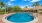  A round swimming pool surrounded by a brick border.