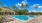  A swimming pool surrounded by palm trees.