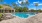  A swimming pool surrounded by palm trees.