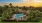  A building with a pool surrounded by palm trees.