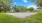  An open sand area in the middle surrounded by trees.